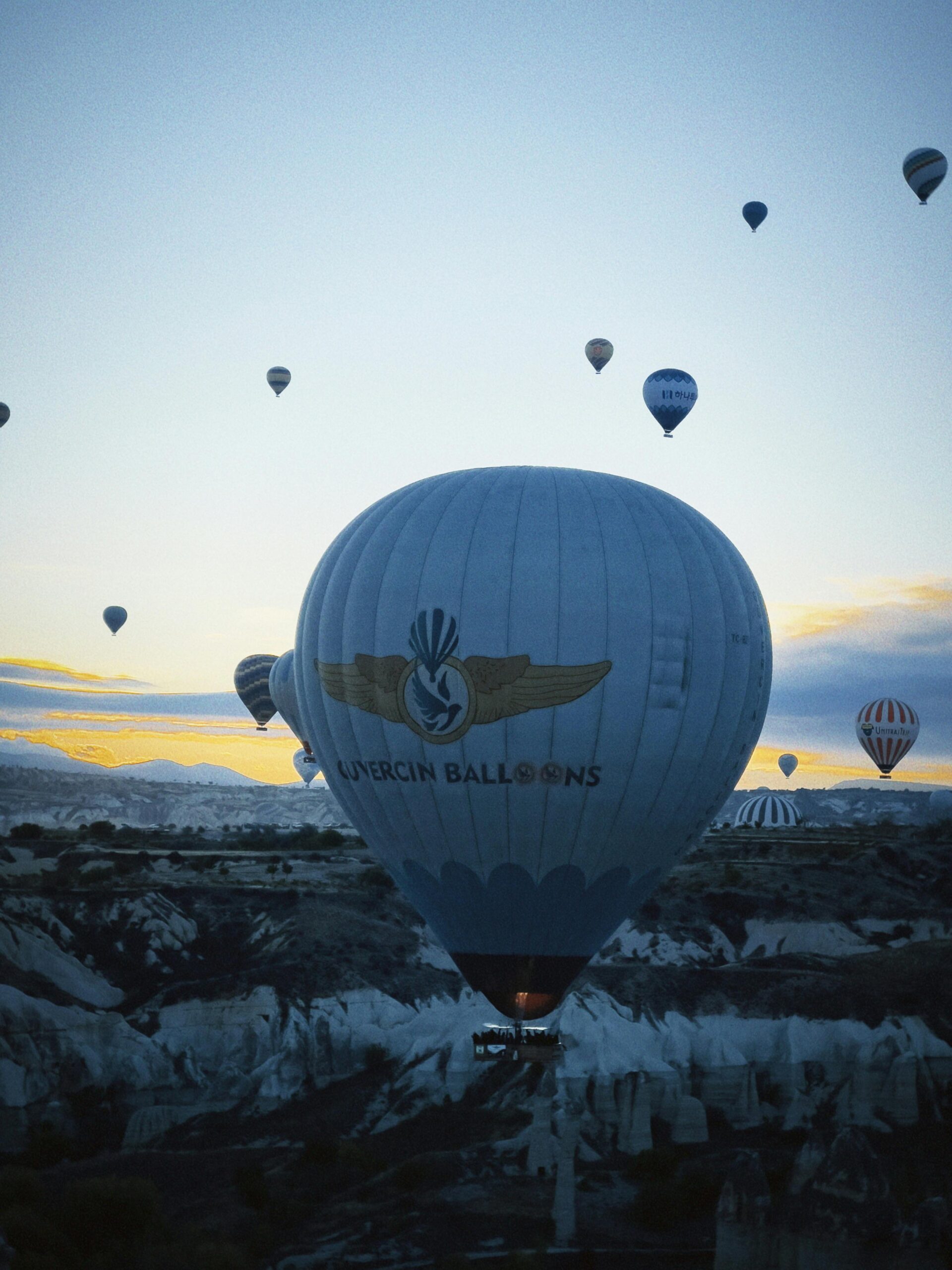 Spectacular view of hot air balloons floating over Cappadocia during sunrise.